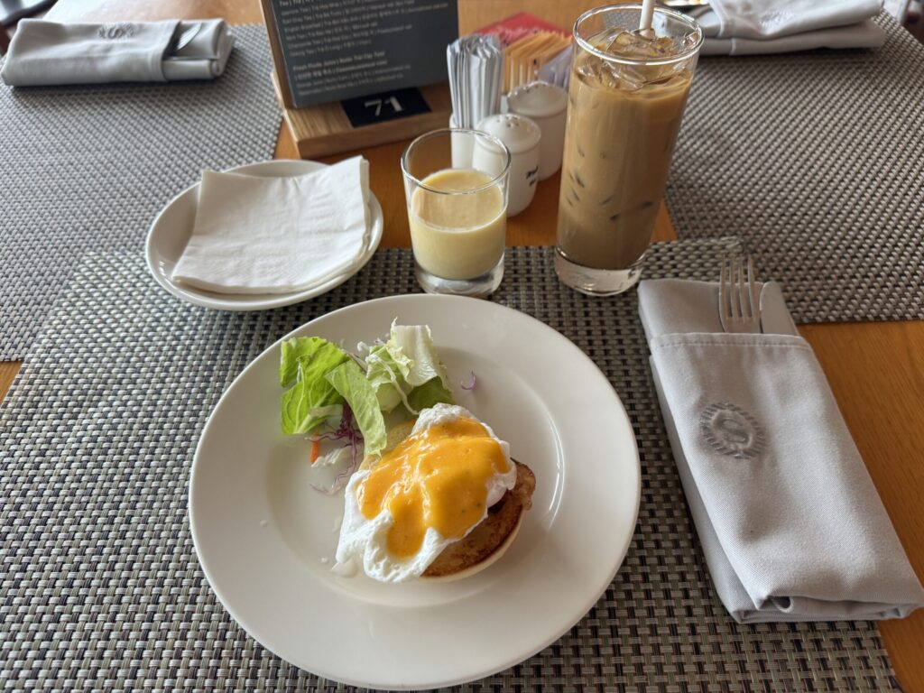 エッグベネディクトとマンゴーの飲み物やベトナムコーヒーを置いた朝食テーブル
